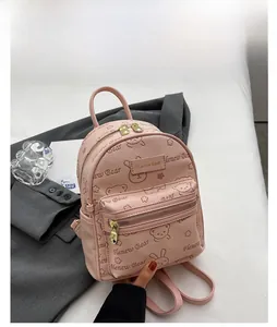 Detail eines rosa Kunstleder-Rucksacks mit süßer Bärenprägung und goldenem Reißverschluss
