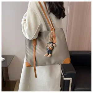 Khaki large capacity tote bag with caramel trim and rabbit plush charm on a model