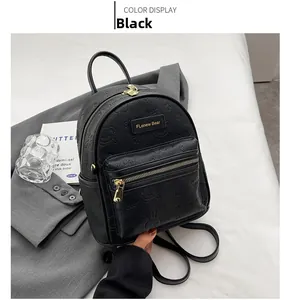 Detailansicht des schwarzen Rucksacks mit Bärenprägung und goldenen Reißverschlüssen