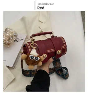 Detail der roten Boston-Zylindertasche mit Goldnieten und ethnischem breitem Schultergurt