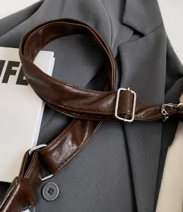 Detail of adjustable leather shoulder strap with silver buckle on a vintage tote bag