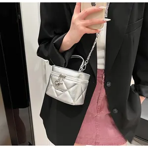 Detailed close-up of a silver quilted mini box bag with chain strap and heart charm zipper
