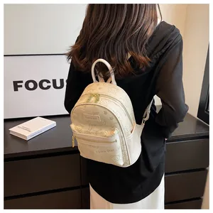 Detail des cremefarbenen Mini-Rucksacks mit süßen Bären-Prints und goldenen Reißverschlüssen