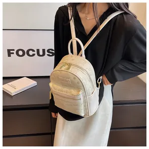 Detailansicht eines cremefarbenen Mini-Rucksacks mit Bärenmuster und goldenen Reißverschlüssen