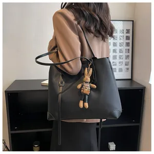 Detail of black large tote bag with durable nylon texture and cute bunny plush charm
