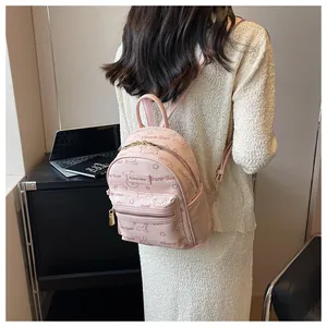 Rosa Mini-Lederrucksack mit Bärendruck am Modell in einer Campus-Umgebung
