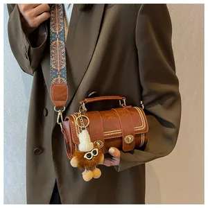 Braune Zylindertasche mit Goldnieten und buntem gewebtem Schultergurt im Ethno-Stil