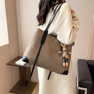 Minimalist large khaki tote bag with black leather straps and cute rabbit charm