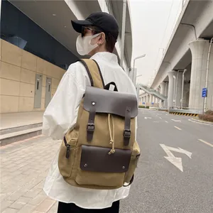 Mochila retro de lona caqui con adornos de cuero usada por un hombre en la ciudad