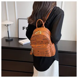Detail eines karamellfarbenen Mini-Rucksacks mit Bärenprint und goldenen Reißverschlüssen