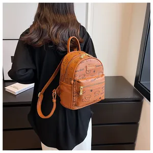 Detailansicht des bärenbedruckten Rucksacks mit goldenen Reißverschlüssen und Textur