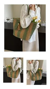 Dettaglio di una borsa tote a righe in paglia con accenti verdi e nappa decorativa