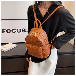 Detail eines braunen Mini-Rucksacks aus Leder mit süßen Bärenprints und Gold-Hardware