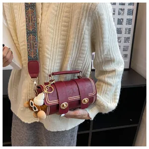 Detail der weinroten Boston Bag mit Lychee Lederstruktur und Ethno-Webschultergurt