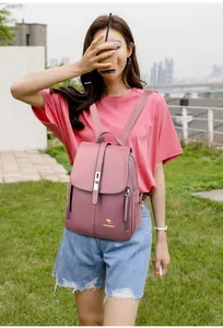 Dettaglio dello zaino in pelle PU rosa cipria con texture litchi e logo in metallo dorato