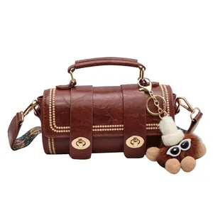 Braune Vintage-Boston-Tasche mit Goldnieten, farbigem Gurt und Plüschtier-Anhänger