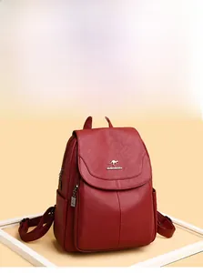 Detail of soft dark red pebbled leather backpack with a classic metal zipper and logo