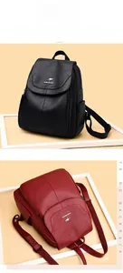 Detail of soft lychee texture leather backpacks in black and burgundy with metal logo