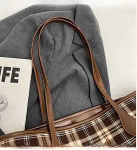 Close-up of the vintage plaid tote bag with brown PU leather handles and metal hardware