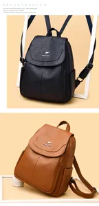 Detail of soft leather backpacks in navy blue and tan with litchi texture and metal logo