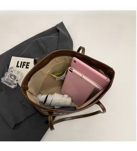 Detailed view of spacious interior storage with compartments in a brown leather tote bag