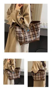 Detail of vintage plaid tote bag featuring brown leather trim and colorful embroidery