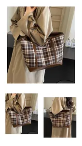 Detail of the vintage plaid tote bag featuring brown leather trim and fine embroidery