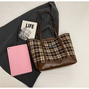 Detailed view of vintage check tote bag with leather trim and cartoon animal embroidery