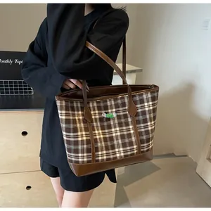 Detail of coffee plaid tote bag with puppy embroidery and reinforced brown leather straps