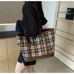Detail of checkered tote bag with dachshund embroidery and brown leather trim