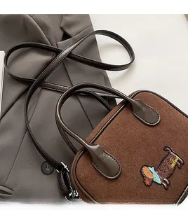 Brown suede handbag featuring dachshund embroidery and premium silver hardware detail