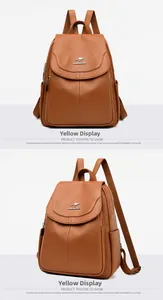 Detail view of the yellow leather backpack featuring soft lychee texture and kangaroo logo