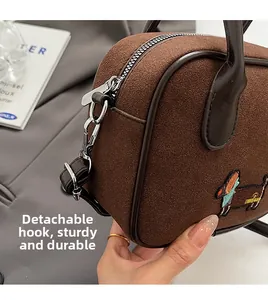 Detail of suede texture, dachshund embroidery, and sturdy detachable D-ring hardware