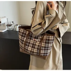 Close-up of retro plaid tote bag with dachshund embroidery and brown leather trim detailing
