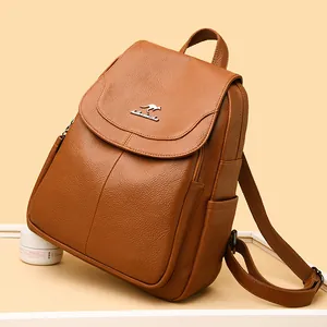 Retro brown pebble leather backpack for women with metal kangaroo logo on warm background