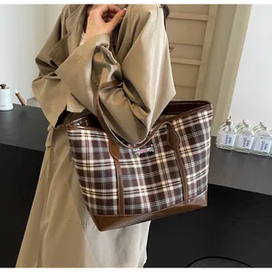 Detail of vintage brown plaid tote bag with high-end leather trim and embroidered patch