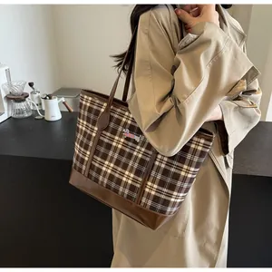 Detail of checkered tote bag with dachshund embroidery and dark brown leather straps