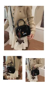 Detail of black dachshund embroidered canvas bag with cute dog and chocolate charms