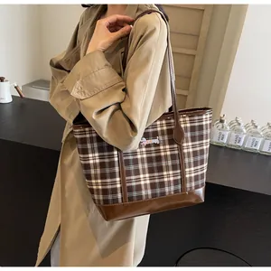 Detail of vintage plaid tote bag with brown leather straps and dachshund embroidery