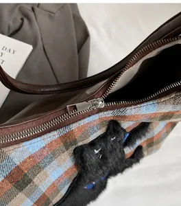Detailansicht des glatten Metallreißverschlusses und des Innenraums der Karo-Tasche