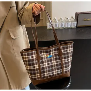Detail of vintage plaid tote bag featuring a small dachshund embroidery and leather trim