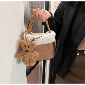 Detail view of brown suede handbag with white faux fur trim and cute bear charm
