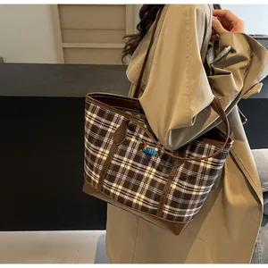 Close-up of tartan plaid tote bag with dog embroidery and brown leather trim details