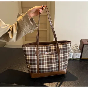 Detail of vintage brown plaid tote bag featuring a cute dachshund dog patch and leather handles