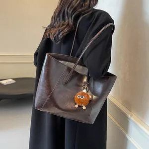 Grand sac cabas marron foncé en similicuir avec un joli charme de monstre en peluche
