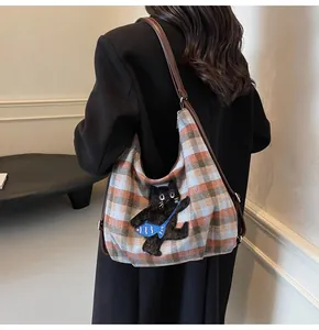 Detailaufnahme der orangefarbenen Karotasche mit niedlicher Katzen-Stickerei
