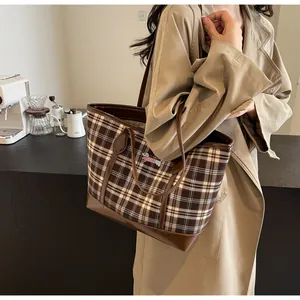 Detail of checkered tote bag featuring dachshund embroidery and premium leather trim