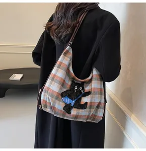 Detailansicht der karierten Tragetasche mit Katzen-Stickerei und Leder-Schultergurt