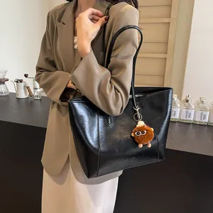 Grand sac cabas noir minimaliste en similicuir avec breloque peluche monstre et anses
