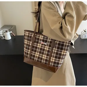 Detail of vintage plaid tote bag with dachshund embroidery and dark brown leather straps